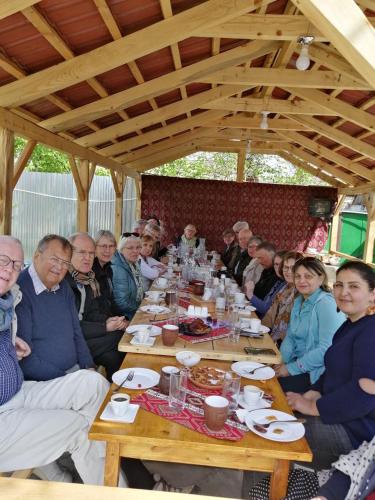 a group of people sitting around a table at Ashtarak Garden GuestHouse in Ashtarak