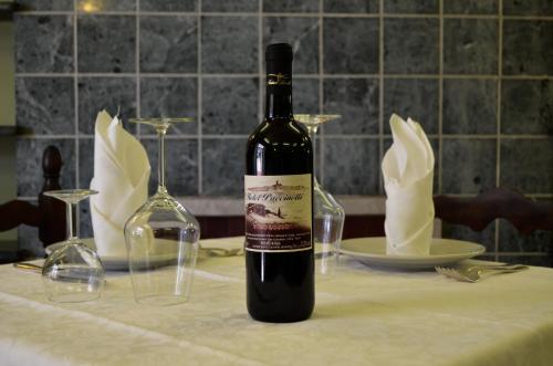 una bottiglia di vino seduta su un tavolo con bicchieri di Hotel Puccinelli a Lido di Camaiore