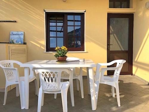 a white table and chairs with a vase on it at Bambiniello in Anacapri