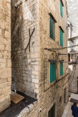 a stone building with green windows and a sign on it at Golden Gate Luxury Rooms - Unique UNESCO Location in Split