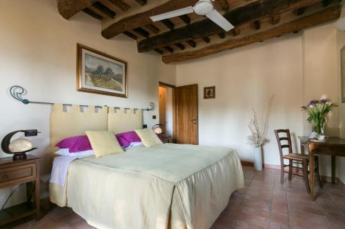 a bedroom with a bed and a table and a desk at Agriturismo Il Castagnolino in San Gimignano