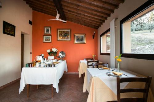 un restaurante con dos mesas con manteles blancos en Agriturismo Il Castagnolino, en San Gimignano