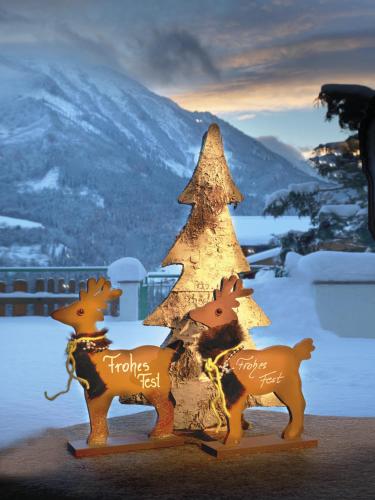 a christmas tree and two reindeer decorations with the words happy new year at Aktivhotel Alpendorf in Sankt Johann im Pongau