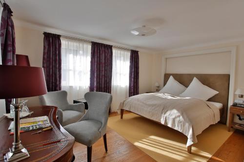 a bedroom with a bed and a desk and a chair at Hotel-Restaurant Anne-Sophie in Künzelsau