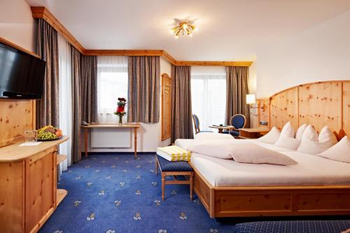 pokój hotelowy z 2 łóżkami i telewizorem w obiekcie Hotel Jägerhof w mieście Gerlos