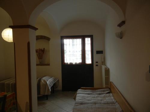 サン・ラッザロ・ディ・サーヴェナにあるcasa vacanza Cicognaのドアと窓のある部屋、ベッド1台が備わる客室です。
