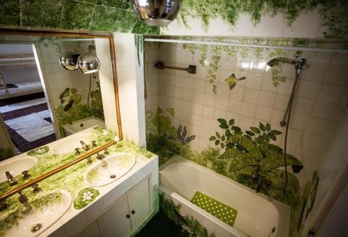 a bathroom with two sinks and a tub and a mirror at Lisbon Surf Villa in Costa da Caparica