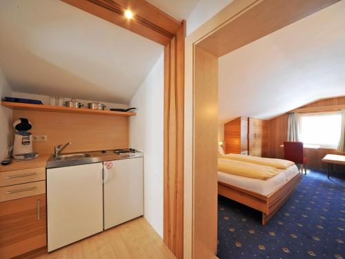 a bathroom with a bed and a sink in a room at Pension Bergkristall in Heiligenblut