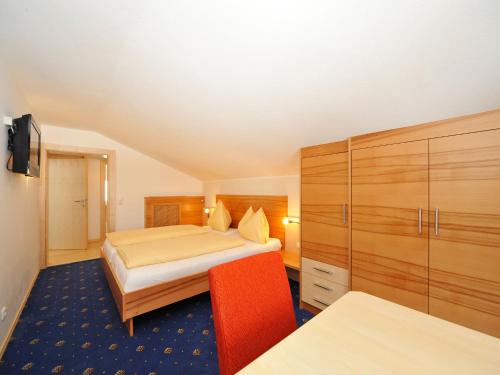 a hotel room with two beds and a cabinet at Pension Bergkristall in Heiligenblut