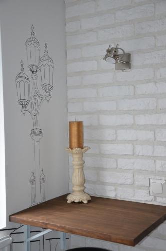 a table with a lamp and a candle on it at Loft Family Hotel in Imatra