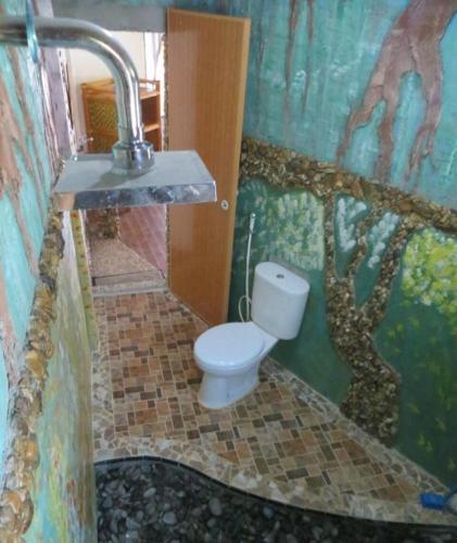a bathroom with a toilet and a sink at Eriono guest house Bukit lawang in Bukit Lawang