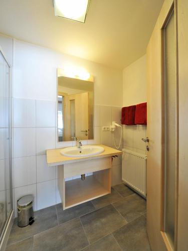 a bathroom with a sink and a mirror at Pension Bergkristall in Heiligenblut