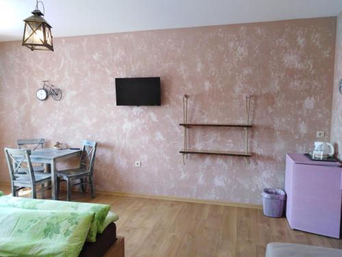 uma sala de estar com uma mesa e uma televisão na parede em Ubytování U Janča em Lednice