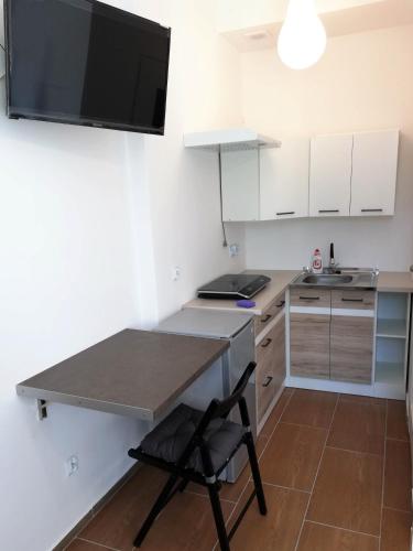 a small kitchen with a table and a chair at Złota Leśniczówka in Rydzówka