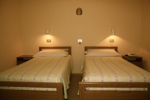 Un pat sau paturi într-o cameră la Albergo Villa Dionori