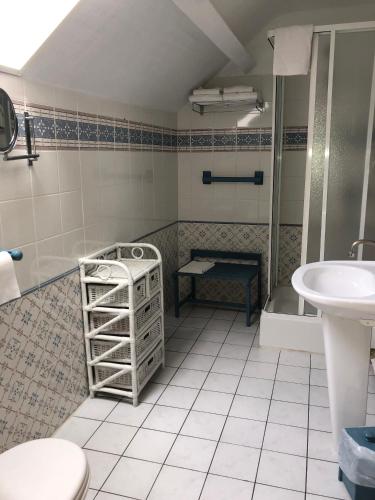 une salle de bain avec toilettes et lavabo dans l'établissement Hôtel d'Arromanches Pappagall, à Arromanches-les-Bains