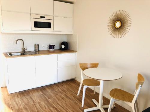 een keuken met een tafel en stoelen en een wastafel bij Apartament Poznańska24 in Bydgoszcz
