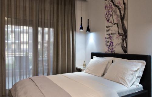 1 dormitorio con 1 cama con sábanas blancas y ventana en CROSS PLAZA, en Stavros