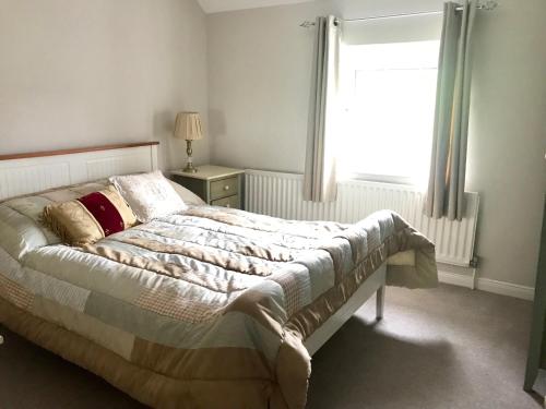 a bed in a bedroom with a window and a bed sidx sidx sidx at Beautiful Family Home in Greyabbey