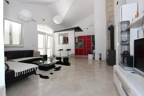 a living room with a couch and a tv at Bungalow 4 Suns in Virpazar