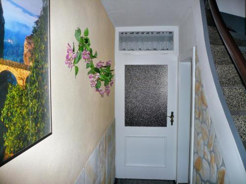 a hallway with a white door with a flower arrangement at Ferienhaus und Ferienwohnung Büttner in Rathmannsdorf