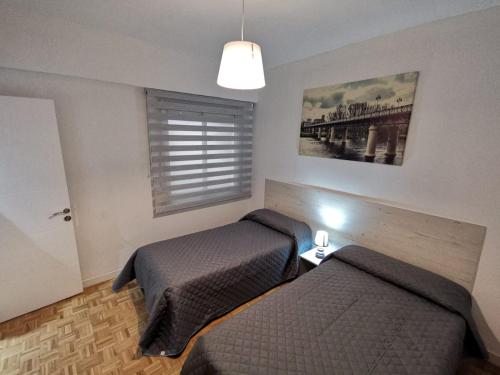 Een bed of bedden in een kamer bij Apartamentos Avenida de La Paz