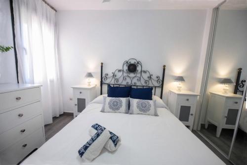サアラ・デ・ロス・アトゥネスにあるAtlanterra Solの白いベッドルーム(青い枕の大きな白いベッド付)