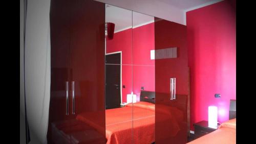 una camera da letto con pareti rosse e un armadietto in vetro di La Pinetina Roma a Roma
