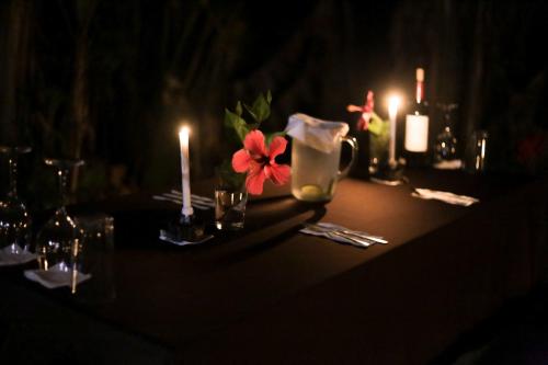 a table with candles and flowers on top of it at Pacuare River Lodge in Bajo Tigre