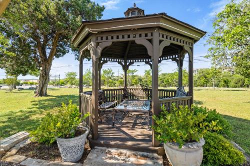 a wooden gazebo with a bench in a park at Mountain Star Lodge in Austin