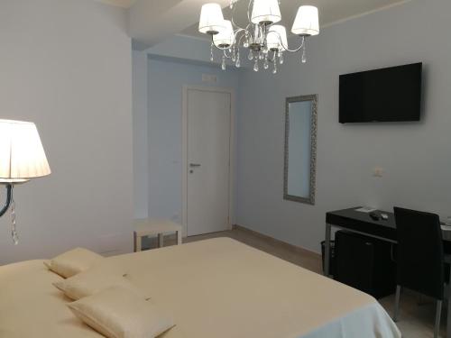 sypialnia z łóżkiem, biurkiem i telewizorem w obiekcie La Finestra sul Mare w mieście Letojanni