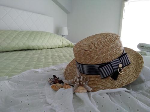a straw hat on a bed with a hat and an octopus at CentroCittà Beach in Roccalumera