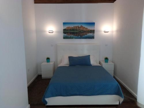 a bedroom with a blue bed and two night stands at Country House Casa dos Chaves in Vila do Conde