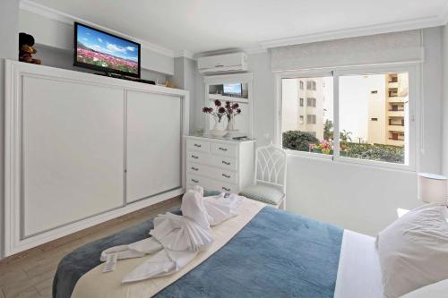 a bedroom with a bed with a tv on the wall at Charming Central Apt in Marbella in Marbella
