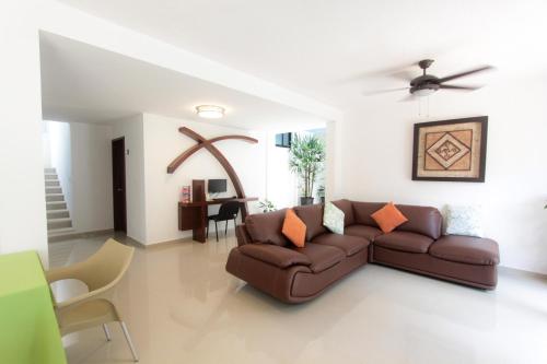 a living room with a brown couch and a table at Hotel Los Girasoles in Cancún