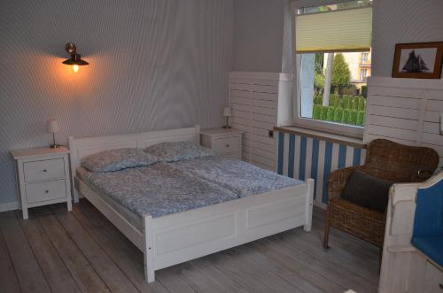 - une chambre avec un lit, une fenêtre et une chaise dans l'établissement Apartament Dark Amber- 3 rooms grand piano, à Świnoujście