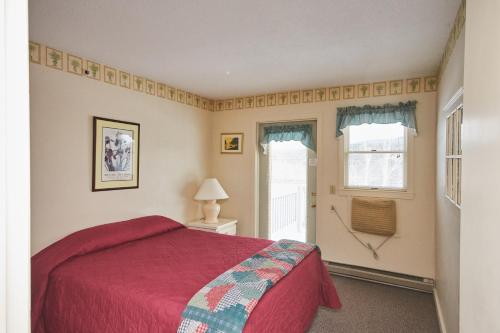 ein Schlafzimmer mit einem roten Bett und einem Fenster in der Unterkunft River View Resort in Bethel