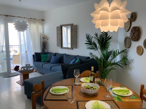 a living room with a table and a blue couch at Kings Palace Indigo 109 in Paphos