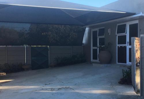 a house with a blue awning over a patio at Ammabed Accommodation in Caledon