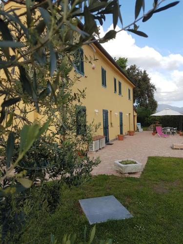 a yellow building with a courtyard in a yard at Podere Gabry in Arena Metato