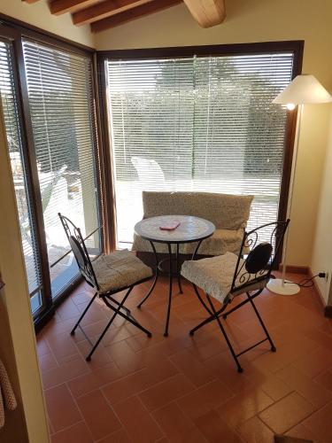 a dining room with a table and chairs in front of a window at Podere Gabry in Arena Metato