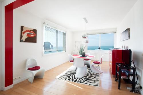 un soggiorno bianco con tavolo e sedie di The Panoramic View 120M2 Private garage a Étretat
