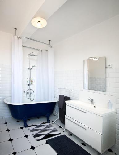 La salle de bains est pourvue d'une baignoire bleue et d'un lavabo. dans l'établissement The Best View 120M2 Panoramic View Private Garage, à Étretat