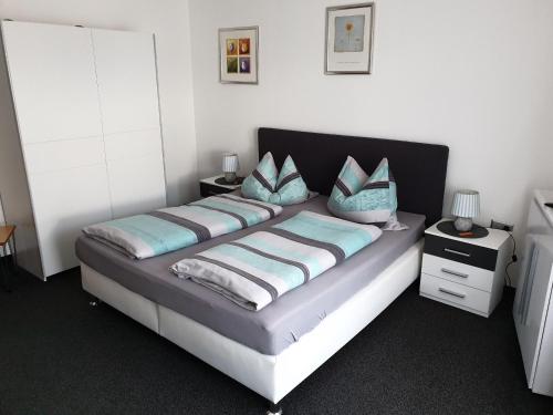 1 dormitorio con 1 cama grande con almohadas azules en Pension Sabine, en Oberstaufen