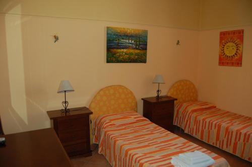 a hotel room with two beds and a table at Il Giardino Del Sole in Agnone Bagni