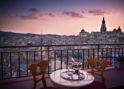 a table and chairs on a balcony with a view of a city at Almunia de San Miguel in Toledo
