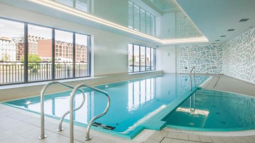 a large swimming pool in a building with windows at EGH Waterlane Island Apartment in Gdańsk