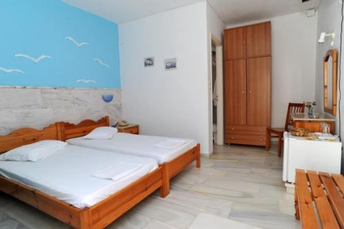 a bedroom with a large bed and a kitchen at Akrogiali Hotel in Agios Sostis