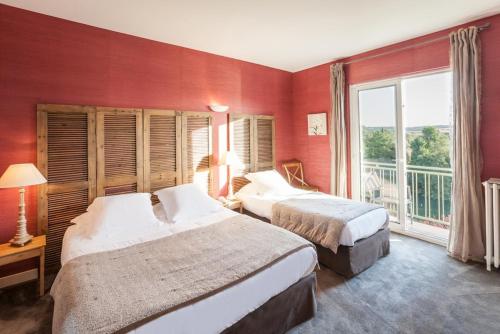 a hotel room with two beds and a large window at hôtel restaurant Beau-rivage in Mansle
