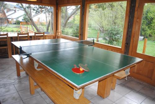 a ping pong table in the middle of a room at Dormi del Pellin in San Martín de los Andes